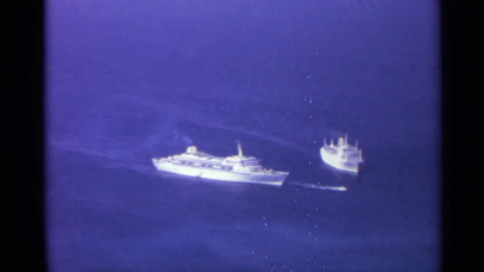 1967 8mm frame showing two distant white vessels moving across blue open water, likely near the US Virgin Islands.