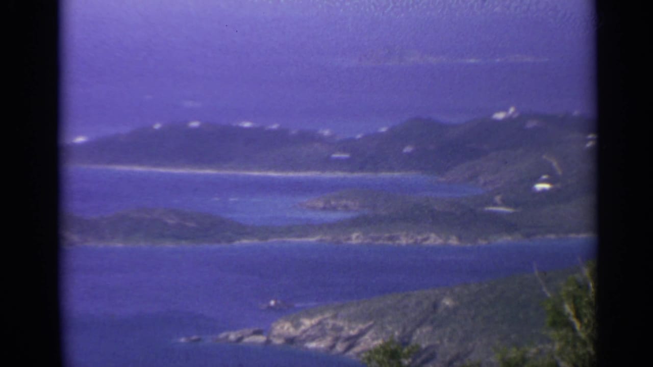Distant green islands and blue water seen from a high overlook.