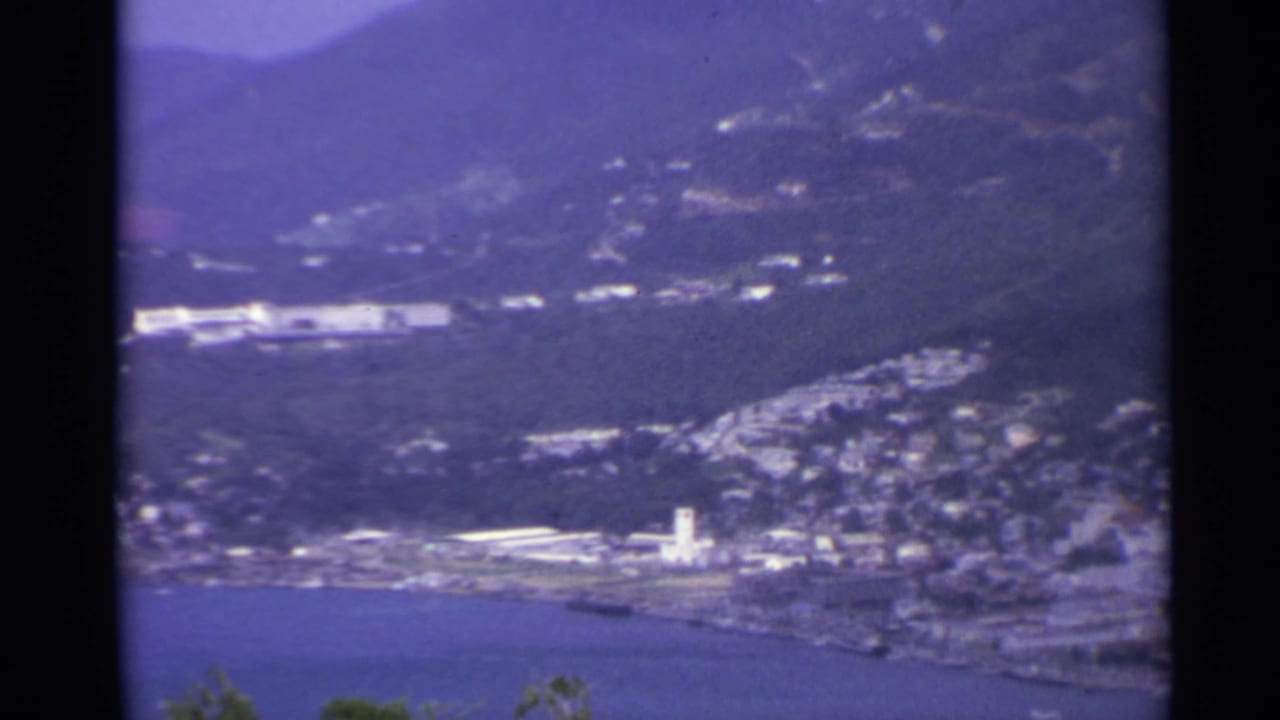 Bayfront town and hillside buildings seen from above.