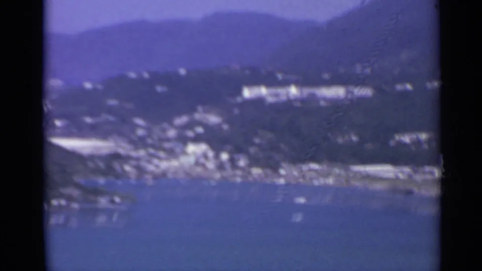 Elevated 8mm view of a coastal settlement and harbor, likely in the US Virgin Islands based on clip metadata.