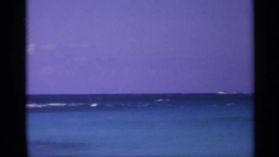 1967 US Virgin Islands 8mm frame showing open blue water, a level horizon, and a purple sky, with no people or buildings visible.