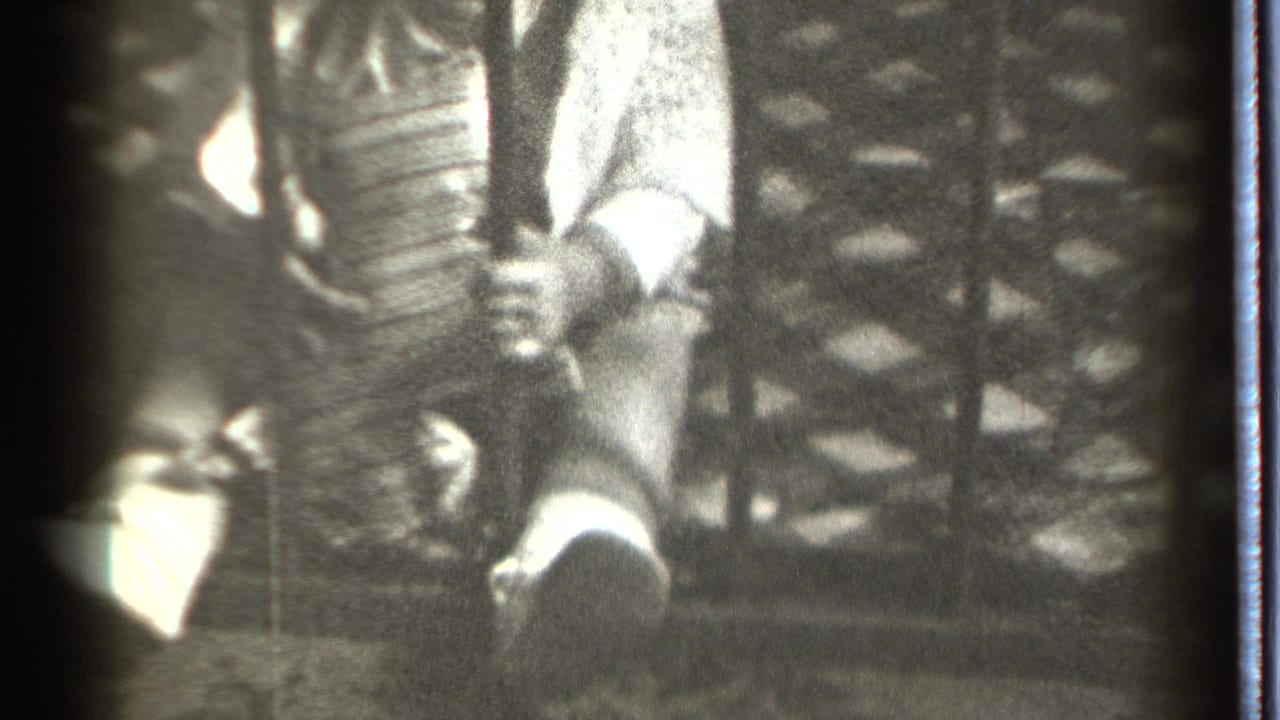 Infant's hand closes around a vertical bar near a patterned background.