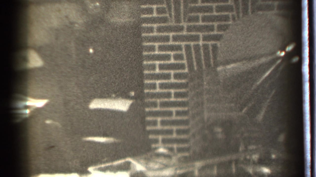 Dim black-and-white view of brickwork and a shadowed indoor fireplace area.