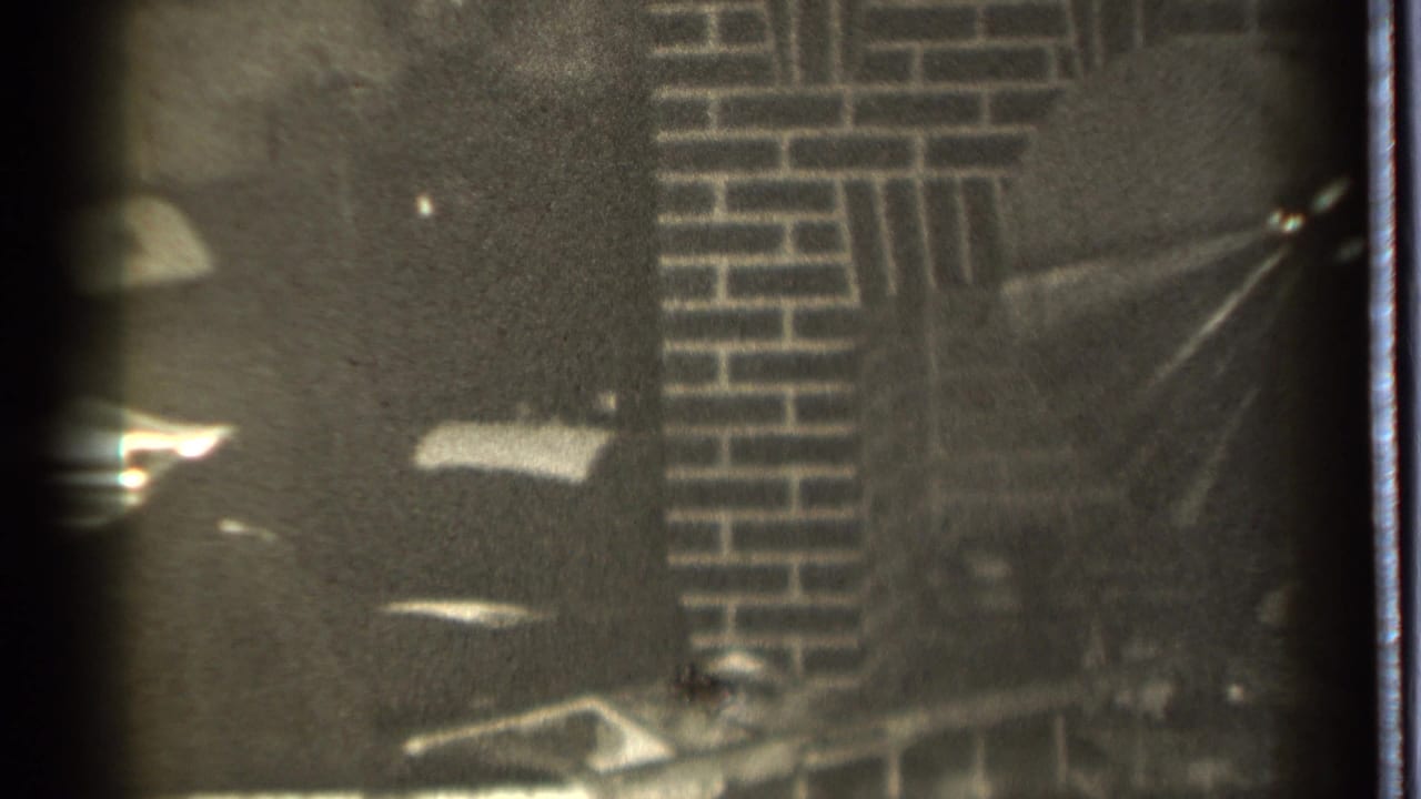 Brick fireplace area with dark shadows, soft focus, and visible film-edge marks.