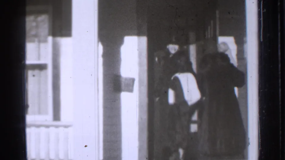 Family members in coats and hats gather at the doorway of a Danielson, Connecticut house in 1939 home-movie footage.
