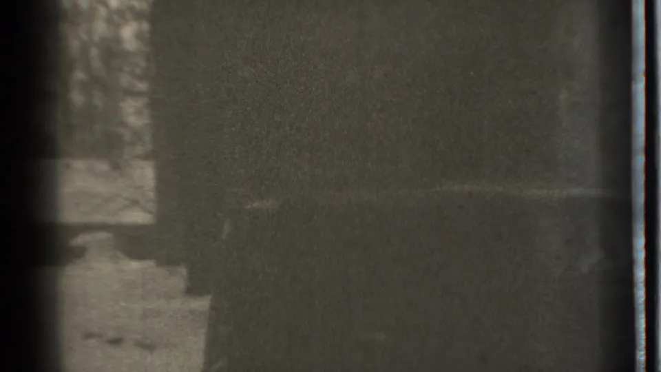 1939 Danielson, Connecticut 8mm frame showing snow, bare trees, a dark vertical shadow, and heavy film grain.