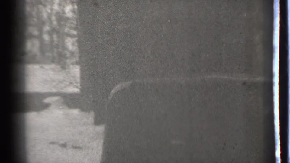 1939 Danielson, Connecticut home-movie frame showing a dark car edge, snow-covered ground, and bare trees.