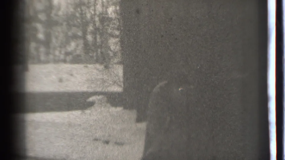 Danielson, Connecticut 1939 home-movie frame showing a dim wall or doorway with a barely visible figure near pale ground and trees.