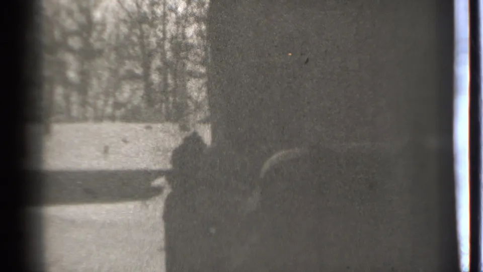 A shadowed figure or object appears close to a dark wall in this grainy 1939 Danielson home-movie frame.