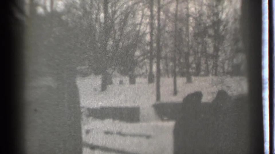 Black-and-white Danielson, Connecticut home-movie frame showing bundled family figures grouped in a snowy yard in 1939.