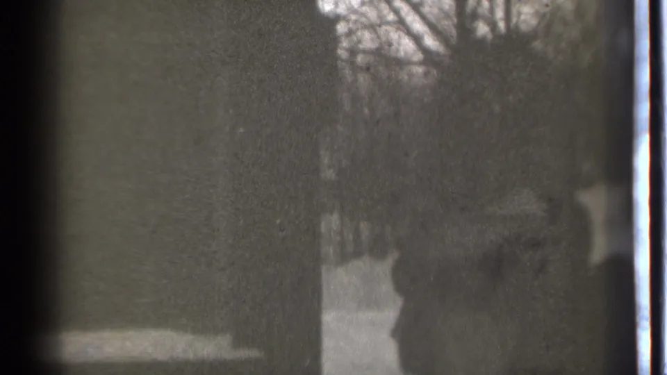 Grainy 1939 home-movie frame showing shadowed human forms in a snowy Danielson winter setting.