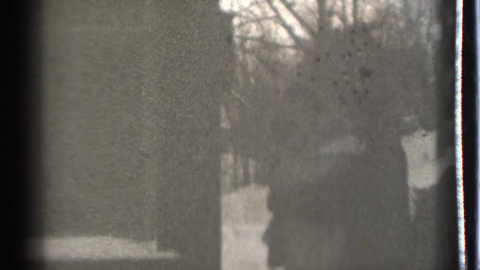 A soft, grainy 8mm frame with a silhouetted person in a snowy Danielson, Connecticut winter landscape.