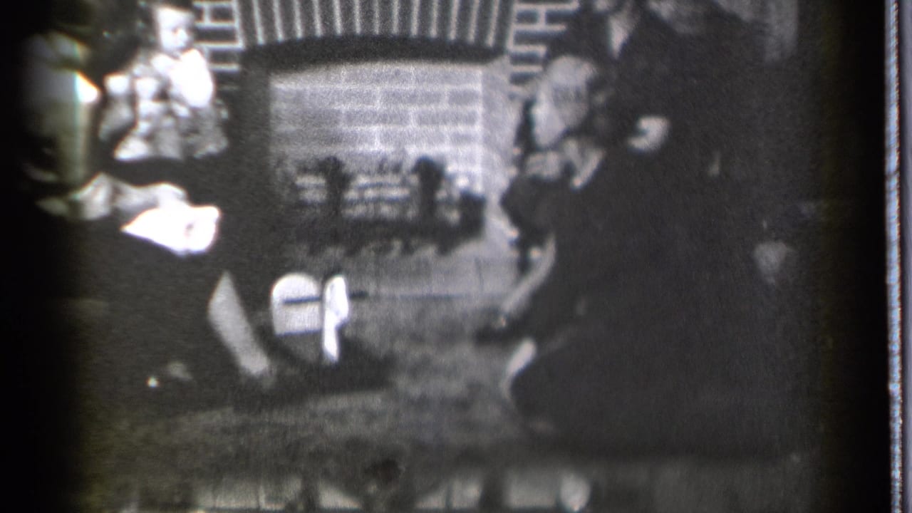 1939 Danielson, Connecticut home-movie frame showing several people gathered around a brick fireplace in a dim room.
