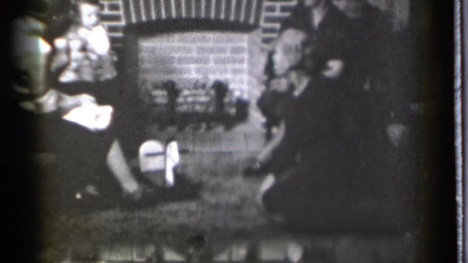 1939 Danielson, Connecticut home-movie frame showing several people gathered around a brick fireplace in a dim room.