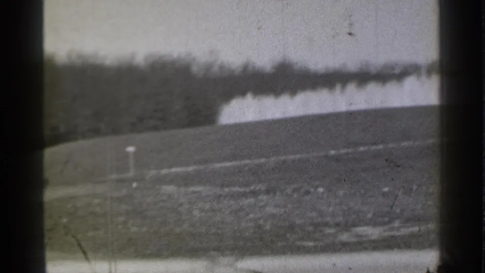 1939 Danielson, Connecticut frame of an empty golf course view with a marker post, distant trees, and a pale fountain-like feature.