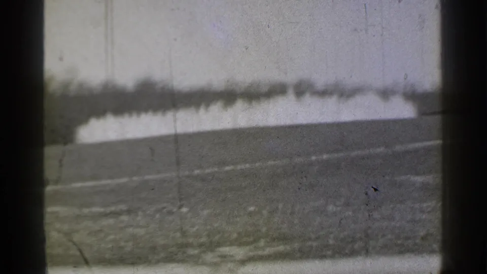 1939 Danielson, Connecticut 8mm view of an empty golf course, with sloped turf, distant trees, and a pale water feature.