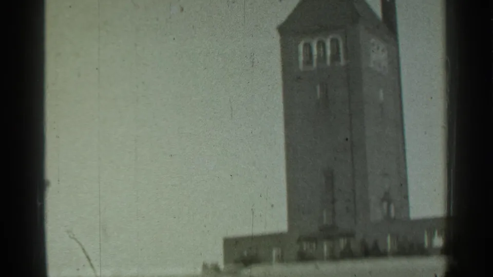 1939 Danielson, Connecticut frame isolating the upper brick tower with arched openings, pointed roof, and a narrow adjacent roofline.