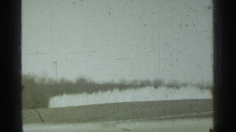 A shifted 1939 Danielson frame shows mostly pale sky through the window, with a low blurred landscape edge and dark mullions.