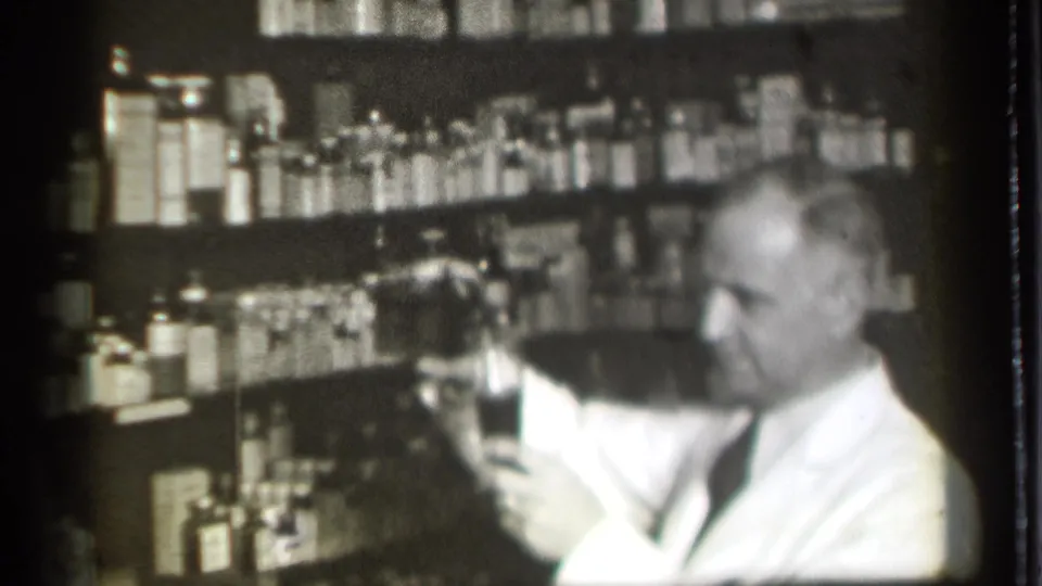 The final frame shows the older pharmacist in profile with a glass, surrounded by shelves of bottles in the pharmacy interior.