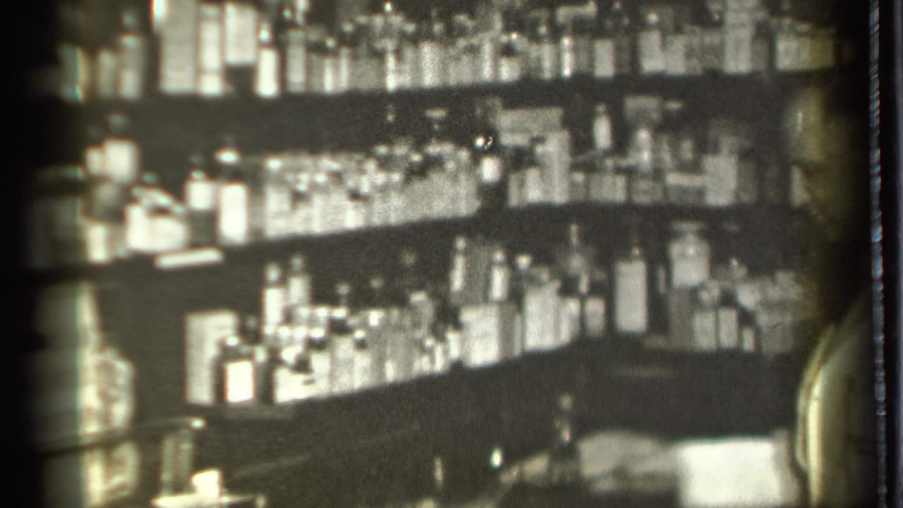 Pharmacy shelves filled with bottles and jars behind a counter.