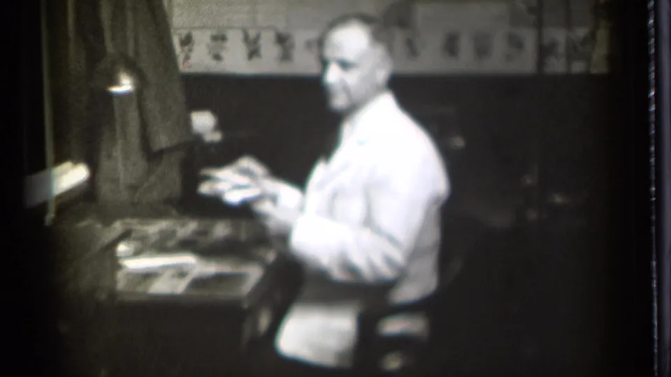 The 1939 Danielson office scene shows the seated man turning partly toward the camera with hands raised above papers on the desk.