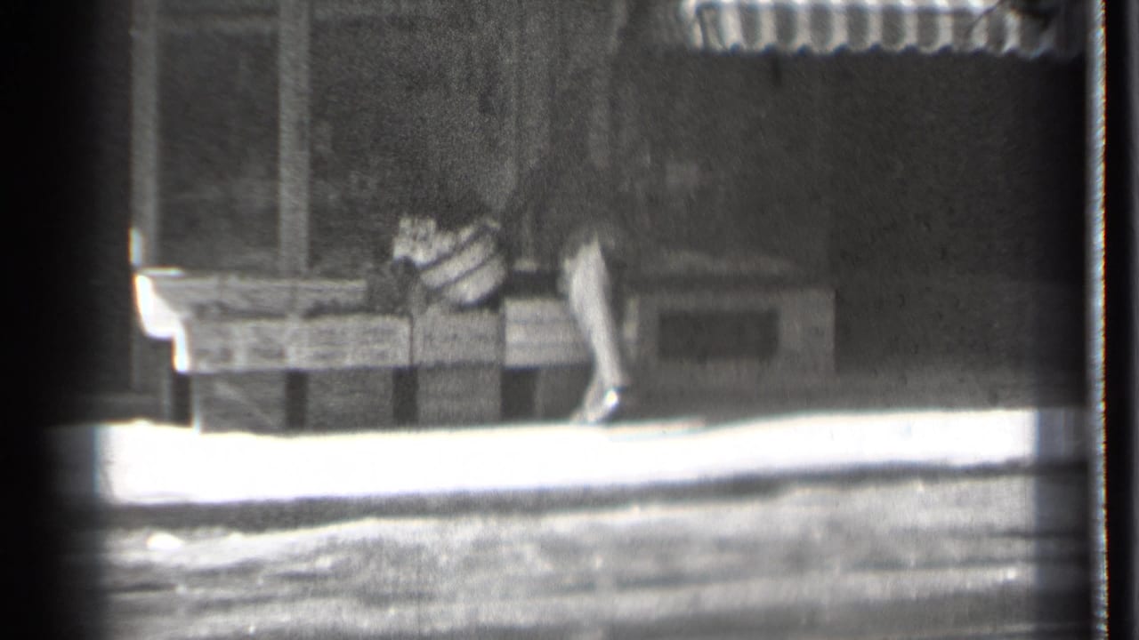 Pedestrian passes market crates beside a storefront window.