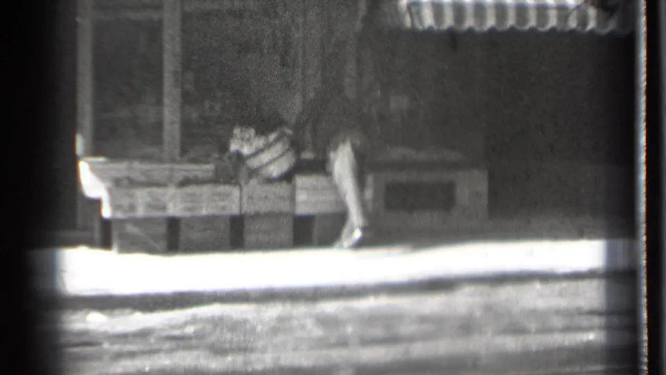 A pedestrian moves past wooden display crates outside a Danielson storefront, with the awning and sidewalk visible in the 1939 street scene.