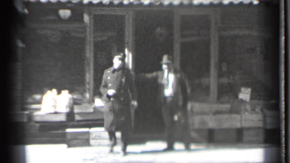 In Danielson, Connecticut in 1939, two adult men appear to argue on a sidewalk outside a storefront with goods set near the window.