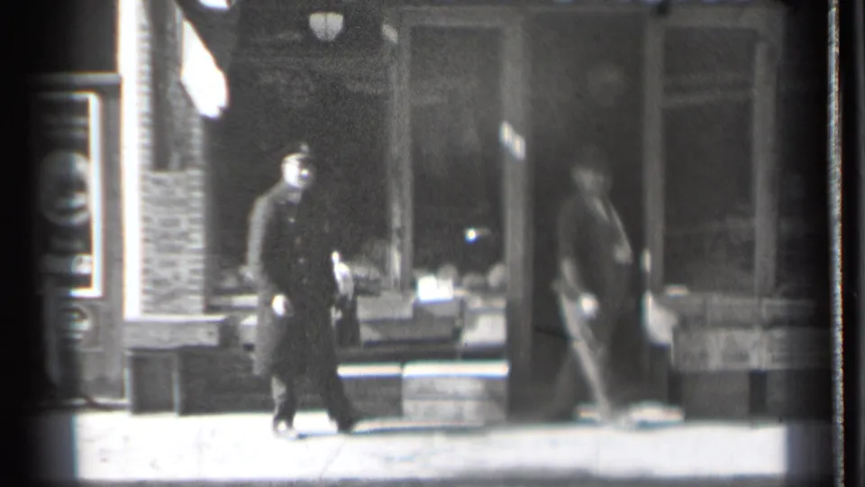 In Danielson, Connecticut, a dark-coated man walks near another man in a suit outside a storefront, consistent with the supplied 1939 home-movie metadata.