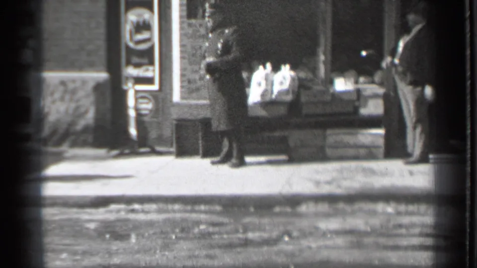 1939 Danielson, Connecticut street view with pedestrians in coats near a storefront display and sidewalk signage.