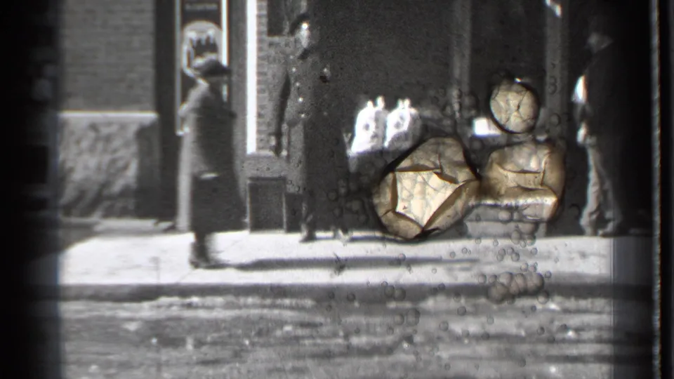 Danielson storefront scene with pedestrians near the sidewalk and a damaged or stained area on the 8mm frame.