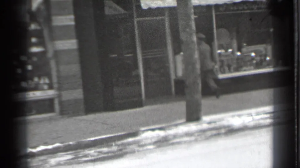A Danielson storefront and utility pole dominate the frame as the snowy curb remains visible in this 1939 street scene.