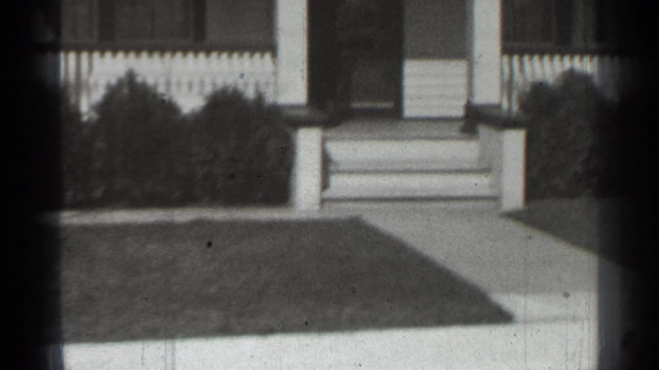 Front porch with white columns, steps, fence, shrubs, walkway, and lawn.
