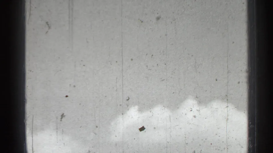 A low, clouded sky fills the frame, with 8mm dust, scratches, and exposure variation visible across the image.