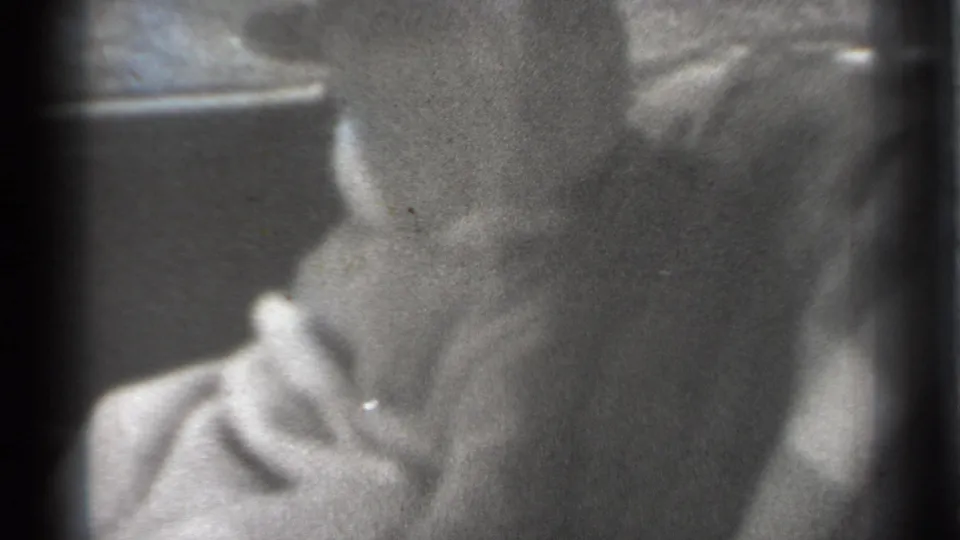 1939 New York home-movie still with a baby's face partly visible in a softly focused car interior, marked by grain and exposure variation.
