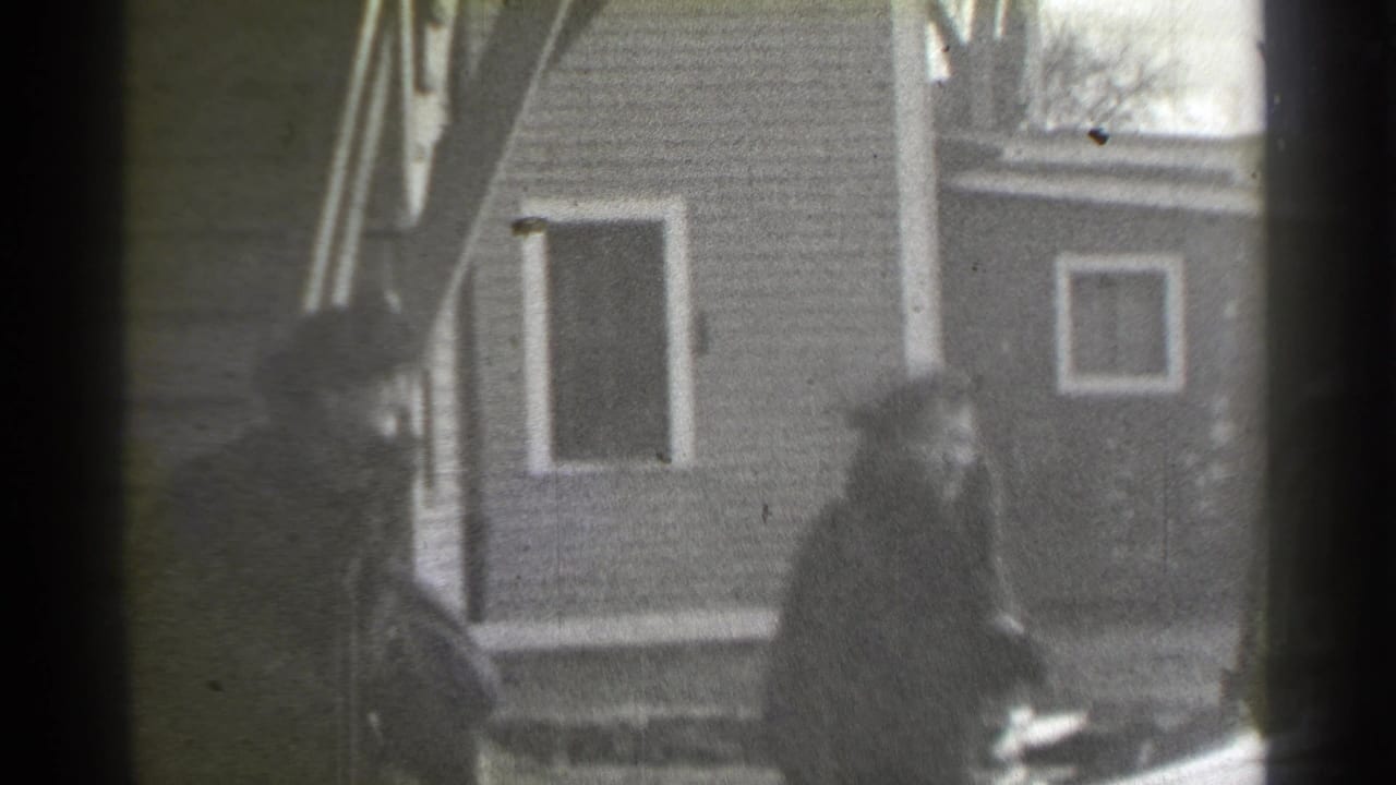Woman walking beside a house toward the right side of the frame.