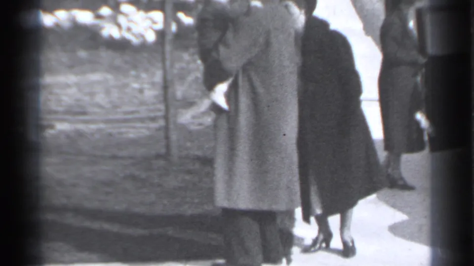 The woman and man stand close together on a New York sidewalk in the 1939 home-movie scene, with other formally dressed adults nearby.