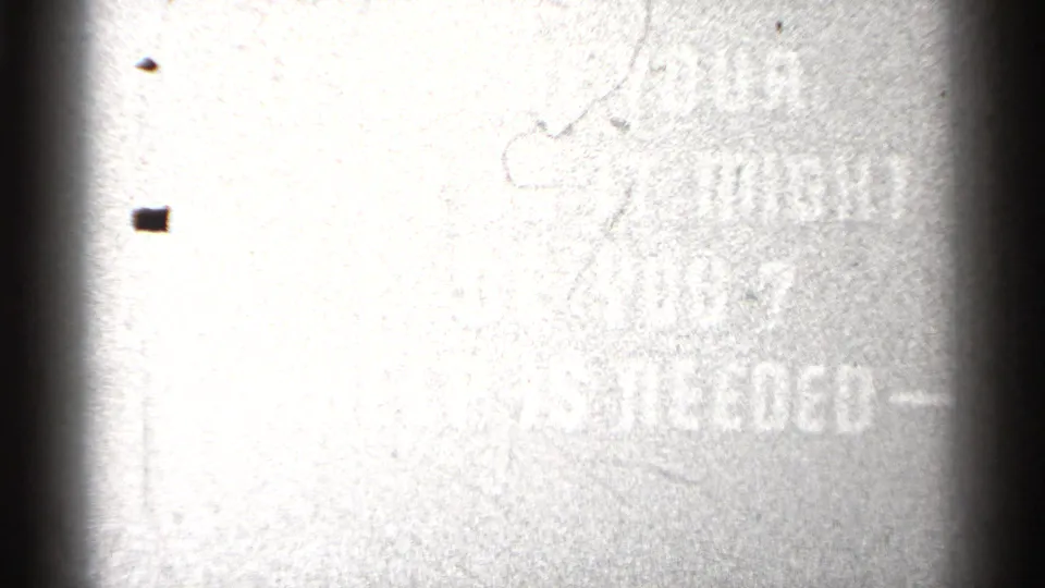Faded 8mm frame where the help-needed message is barely visible through heavy overexposure and film wear.