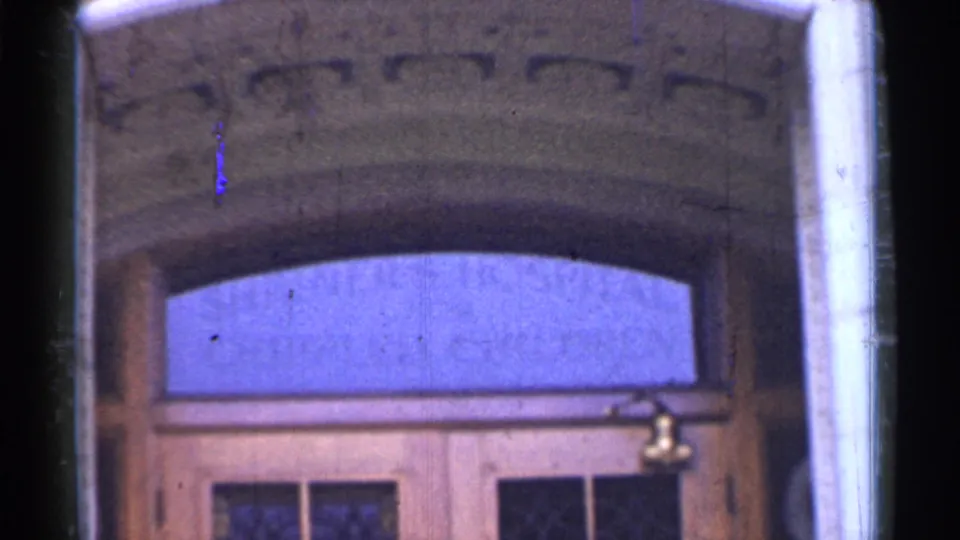 San Francisco hospital entrance in 1944, showing an arched stone doorway, blue transom window, wooden doors, and a small brass fixture.