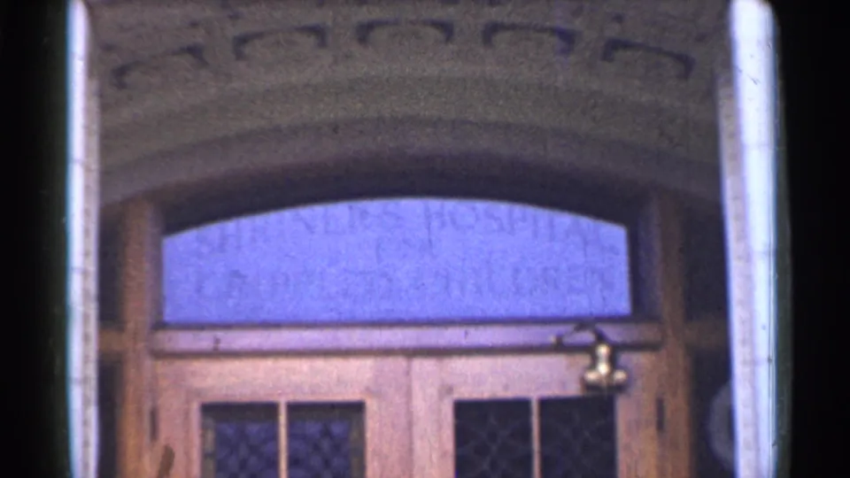 1944 San Francisco 8mm frame showing a large wooden entrance with an arched transom and faint lettering above the doors.