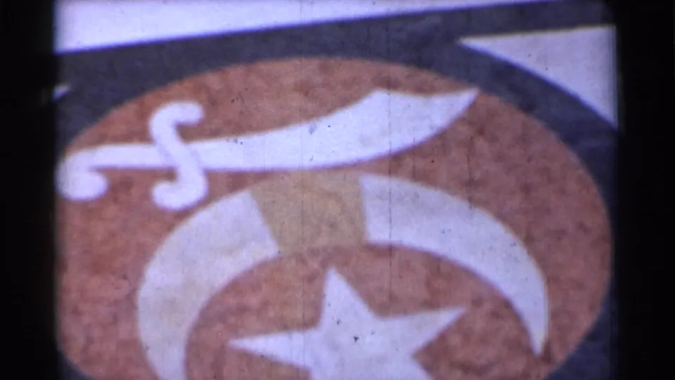 Close 1944 San Francisco view of a symbolic painted emblem with a white sword, crescent, and star on a textured brown background.