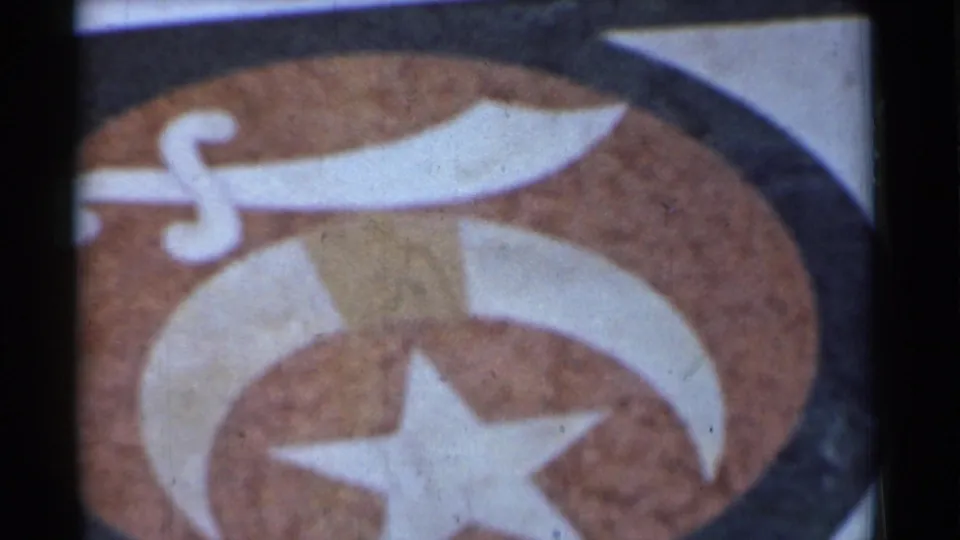 Close 1944 San Francisco frame of the unidentified star, crescent, and sword emblem, cropped by the 8mm film frame.