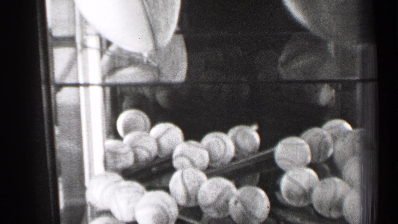Glass display case with stacked baseballs and part of a football visible.