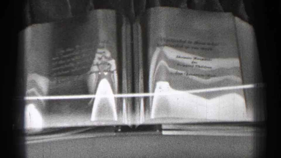 1944 San Francisco 8mm frame showing swan-like decorative forms, reflective surfaces, and a rail within a tiled spa or bath-room interior.