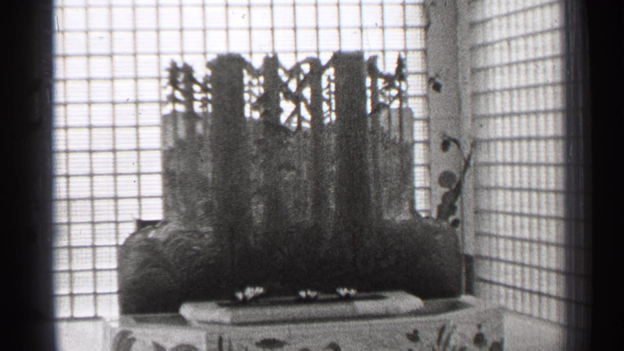 Shoji-style screen behind a dark sculptural centerpiece on a low surface.
