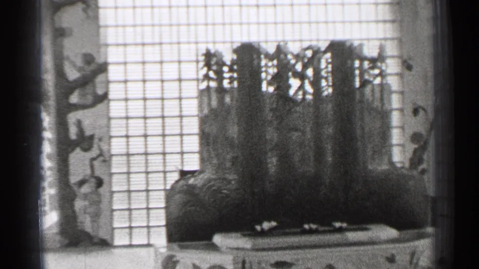 1944 San Francisco frame with a dark temple-like display form, shoji-style grid screens, and carved side panel detail.