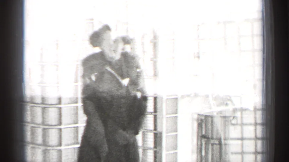 Two adults are faintly visible near bright windows and columns in the final, overexposed frame of the 1944 San Francisco interior scene.