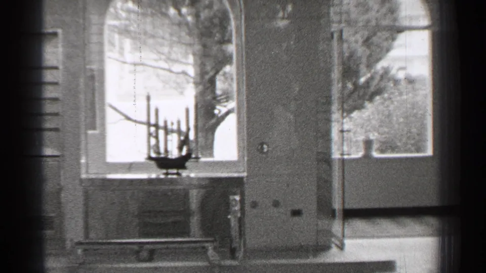 1944 San Francisco hospital ward interior with metal bed frame, large windows, wall radiator or cabinet, and street view beyond the glass.