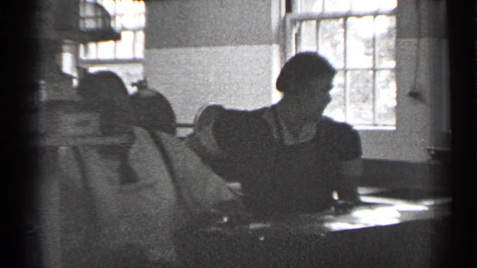 A woman and a suited man sit or stand around a table in a 1944 San Francisco interior.