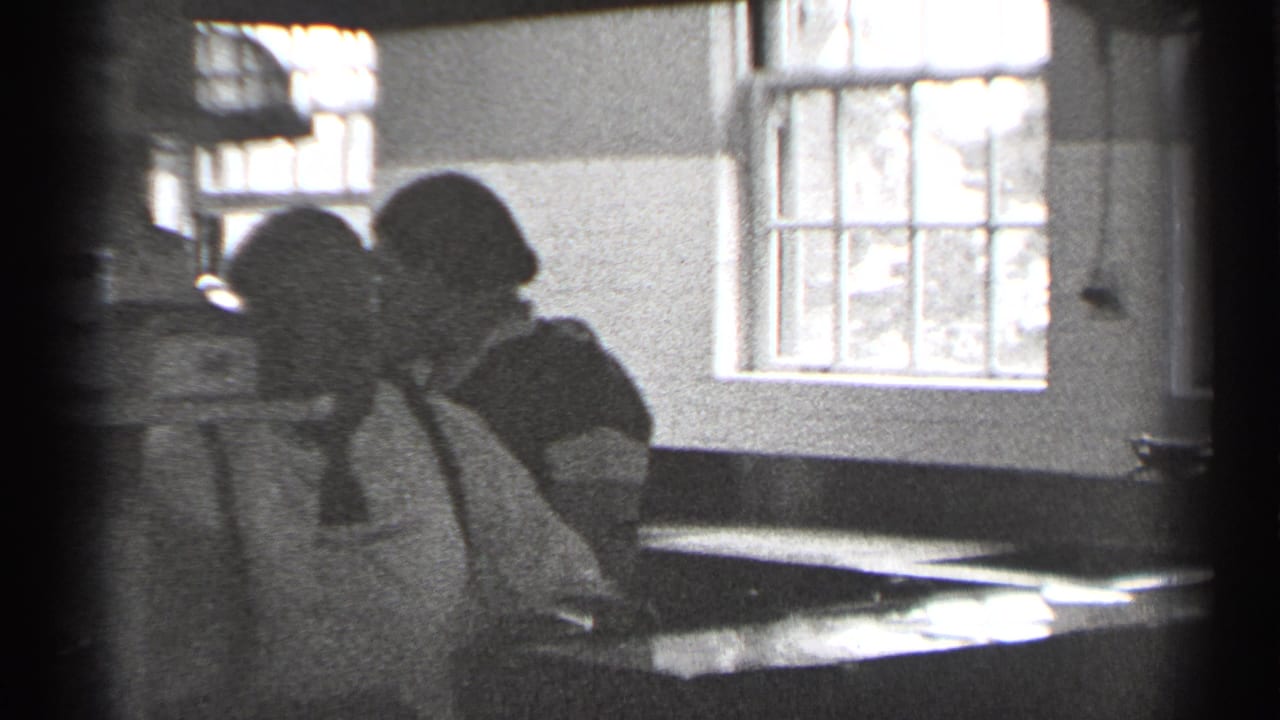 Two women in aprons work at a counter in a San Francisco kitchen-like interior, filmed in black-and-white 8mm around 1944.